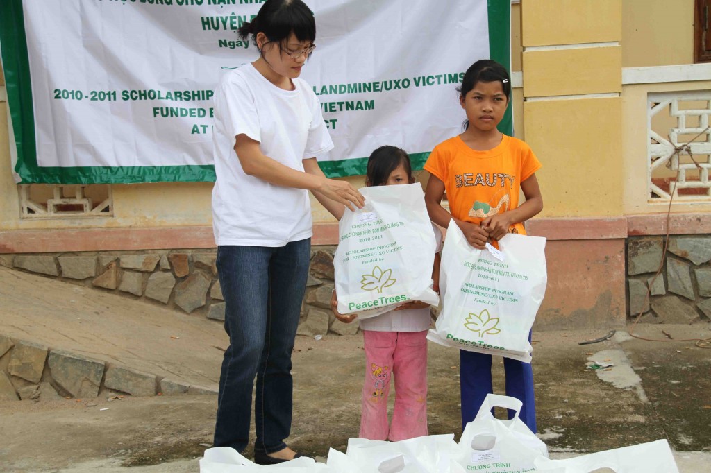 Giang (in orange shirt) accepts her scholarship package from PeaceTrees