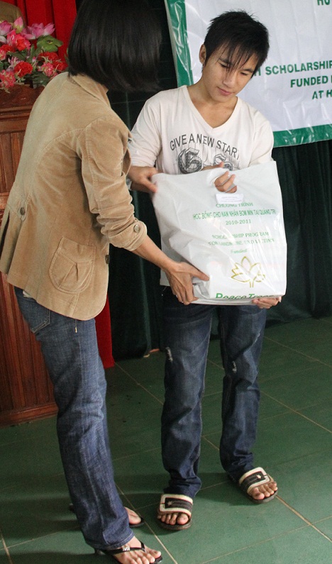 Duong accepts his school supplies from PeaceTrees staffer