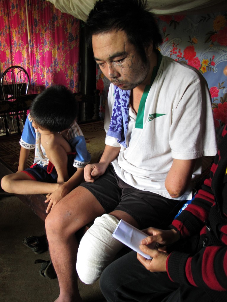 Hieu and his son are still getting used to their new life.  Here, Hieu accepts support from PeaceTrees Vietnam, which will help cover his medical expenses.